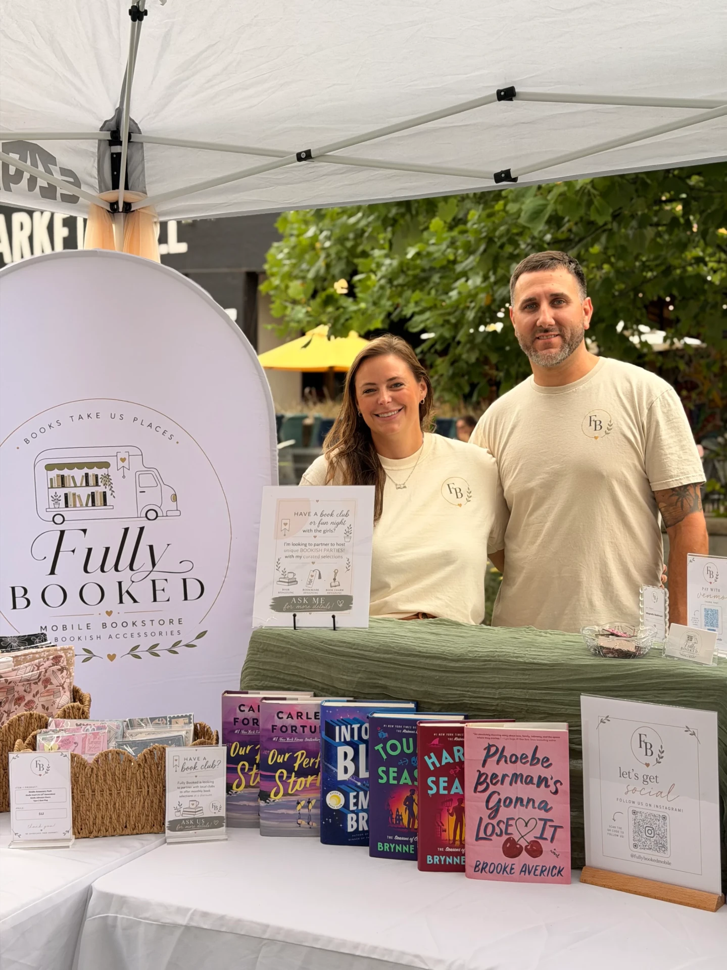 Elisha and her husband at the Fully Booked market booth with books and merchandise