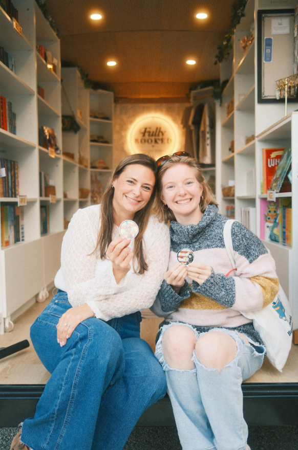 Elisha and her husband at the Fully Booked market booth with books and merchandise